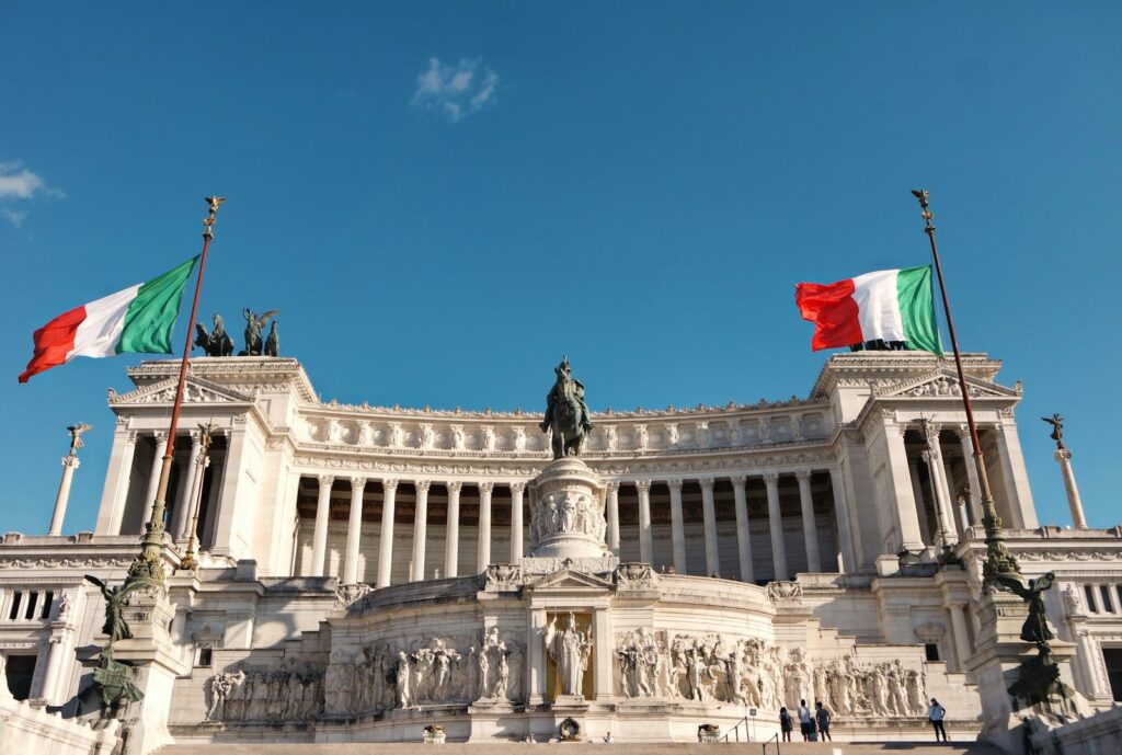 Prédio institucional italiano com estátua, sob céu azul