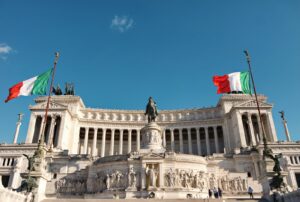 Prédio institucional italiano com estátua, sob céu azul